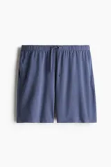 Conjunto de pijama azul de dos piezas en tejido de punto. Incluye una remera de manga corta con cuello redondo y un short con cintura elástica ajustable con cordón y bolsillos laterales.