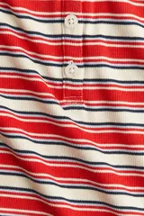 Remera polo de punto acanalado a rayas rojas, blancas y azul marino, con cuello rojo y tapeta de botones.