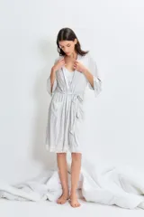 Bata gris claro melange de modal jersey con detalle de puntilla en mangas y ruedo. Tiene lazo para ajustar en la cintura y detalle bordado en el pecho.