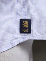 Camisa verde militar de manga larga, confeccionada en mezcla de lino y algodón. Tiene cuello clásico, cierre con botones y un bolsillo en el pecho.