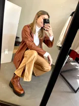 Blazer de cuero sintético color chocolate con cuello solapa y bolsillos con tapa.