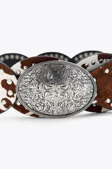 Cinturón de cuero con piezas circulares con estampado animal y tachas. Detalle de apliques metálicos labrados y hebilla metálica circular.