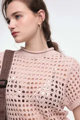 Top negro calado de tejido de punto con cuello alto y mangas cortas.