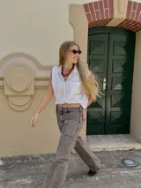 Pantalón jean gris de tiro medio y corte recto, con costuras verticales y bordado de brújula en los bolsillos traseros.