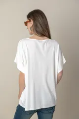 Remera holgada color beige, de escote en V y mangas cortas.