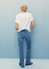 Pantalón de jean celeste de corte recto, tiro medio, con cinco bolsillos, cierre de cremallera y botón, trabillas y bajo deshilachado.