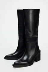 Bota de cuero negra con caña alta, punta cuadrada y tacón ancho.