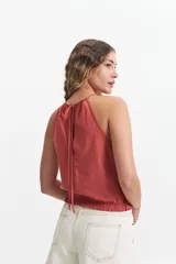 Blusa sin mangas color ladrillo, con cuello halter y elástico en el cuello y la cintura.