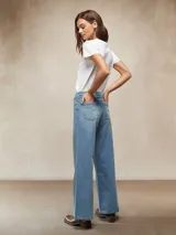 Pantalón de jean negro de tiro alto, corte ancho y pierna recta, con costuras verticales marcadas en el frente y cordón ajustable en la cintura.