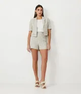 Short de tiro alto con estampado de cuadros en tonos beige y verde, con botones decorativos en la cintura.