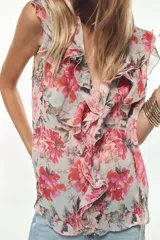 Camisa sin mangas con estampado floral en tonos rosados, escote en V y volantes en el mismo tejido.