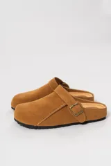 Zueco de gamuza color marrón, con detalles de costuras y hebilla metálica ajustable.