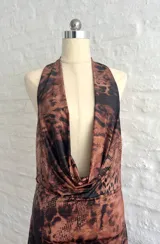 Vestido corto ajustado al cuerpo, con estampado animal print en tonos marrones y negros. Tiene escote en V pronunciado y breteles finos.