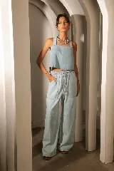Conjunto de denim celeste compuesto por un top corto con tirantes anchos y un pantalón palazzo con cintura elástica y bolsillos laterales.