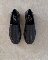 Mocasines negros con suela track y detalle de antifaz con textura croco.