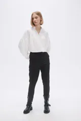 Pantalón negro de vestir, corte slim fit y largo al tobillo.