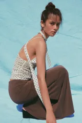 Top blanco con estampado de lunares negros, escote pico, tirantes finos y detalle de foulard en el mismo tejido.