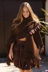 Ruana marrón tejida en lana merino con detalles de lino y flecos.