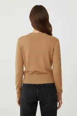 Cardigan de tejido de punto, color negro con rayas horizontales blancas, corte al cuerpo y cuello redondo a la base. Posee cierre frontal con botones dorados.