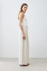 Pantalón palazzo color beige melange de tiro alto con pinzas delanteras y corte amplio.