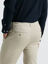 Pantalón chino de hombre color beige, con bolsillos delanteros diagonales, cierre y botón en la cintura. Logo bordado a tono. Confeccionado en 98% algodón y 2% elastano.