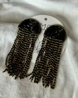 Aros colgantes con base semicircular de cuentas negras y flecos de cuentas negras y doradas.