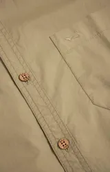 Camisa amarilla de algodón orgánico, manga larga con botones de madera, cuello italiano, calce regular, bolsillo de pecho con logo bordado.
