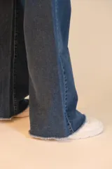 Jean wide leg de tiro alto, color azul oscuro. Tiene dos bolsillos redondeados en la cadera en la parte delantera y dos bolsillos en la parte trasera. Cuenta con botón metálico, cremallera y terminación de ruedo desflecado.