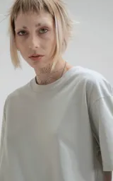 Remera gris de manga corta, cuello redondo y calce regular con recorte en espalda, realizada en algodón premium muy suave al tacto.