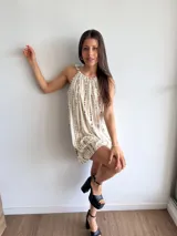 Vestido corto color crudo con estampado de líneas verticales marrones, cuello redondo con frunce y tirantes con lazo.