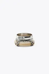 Pack de tres pulseras rígidas para mujer. Incluye una pulsera de resina color crema con apliques metálicos, una pulsera metálica labrada de mayor tamaño y una pulsera metálica labrada más fina.