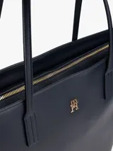 Cartera tote Tommy Hilfiger color azul marino, con doble asa superior y cierre de cremallera. Presenta el logo metálico de la marca en dorado en el frente.