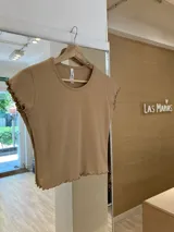 Remera color beige de morley de algodón, manga corta y terminación fruncida en mangas y ruedo.