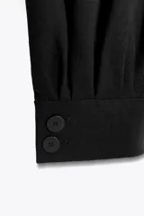 Pantalón de tiro medio confeccionado en hilatura con mezcla de viscosa, color negro. Presenta bolsillos laterales ocultos en costura, bajo acabado en puño con botones y cierre frontal con cremallera, botón y ganchos metálicos.