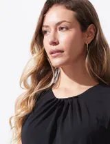 Blusa sin mangas color amarillo, con cuello redondo con frunces delanteros y abertura con botón en la espalda.