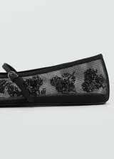 Zapato chatito de malla negra con bordado de lentejuelas y tira con hebilla.