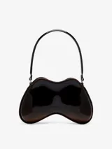 Bolso de hombro con forma orgánica tridimensional, inspirado en un control de videojuegos. Construcción rígida soft-touch, color negro brillante con detalles en marrón oscuro en los bordes. Posee un remache metálico ovalado en el frente y correa fija al hombro.