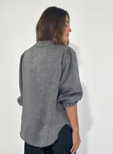 Camisa celeste de lino con mangas 3/4 abullonadas y cuello en V con volados.
