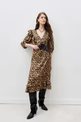 Vestido midi con estampado animal print de leopardo, escote en V cruzado, mangas 3/4 con volados en los hombros, cinturón negro con aplique de flor y volados en el ruedo.