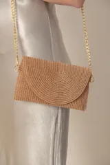 Sobre de fiesta plateado con textura tejida y cadena metálica para colgar.