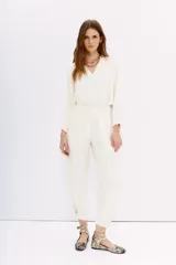 Pantalón sastrero negro con ajuste en el tobillo, tiro alto, bolsillos delanteros y traseros, pinzas en el frente, confeccionado en cupro y viscosa.