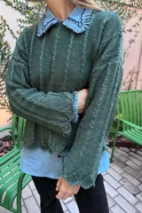 Sweater verde oscuro de tejido de punto con textura y brillo, de grosor intermedio y largo a la cadera.