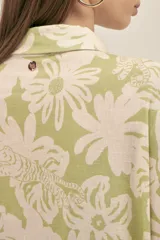 Vestido camisero largo de lino color verde claro con estampado de flores blancas, estilo oversize, con cuello camisero, mangas cortas, bolsillos laterales y botones de madera. Marca Polonio, hecho en Italia.