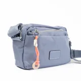 Bandolera celeste de tela impermeable con correa regulable, cierre superior y bolsillo frontal con cierre.