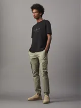 Remera negra de algodón regenerado con cuello redondo y logo Calvin Klein Jeans brillante en el frente.