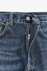 Pantalón de jean azul de corte wide leg, tiro alto y largo hasta el tobillo.