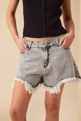 Short de jean gris con efecto lavado, tiro alto y ruedo desflecado.