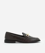 Zapato mocasín de cuero color marrón oscuro con detalle metálico dorado en la parte delantera.