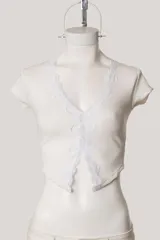 Remera corta negra de tejido acanalado, con escote en V y detalle de puntilla en el borde.