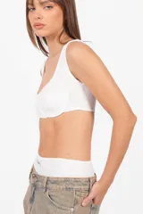 Conjunto de microshort y top blanco de tejido de punto. El top es un corpiño con aros en la copa y terminaciones envivadas. El short tiene elástico en la cintura.